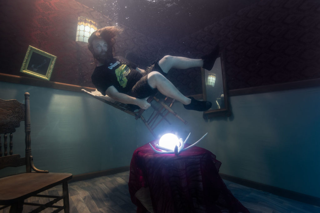 bearded man floating in an underwater room