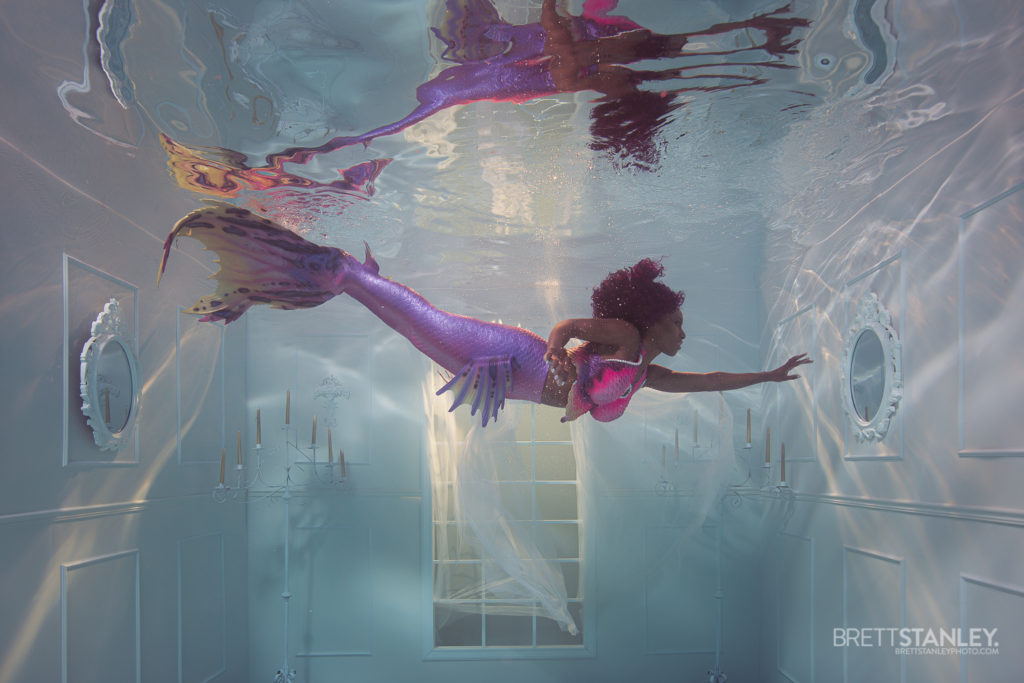 black mermaid in an underwater room for a photoshoot