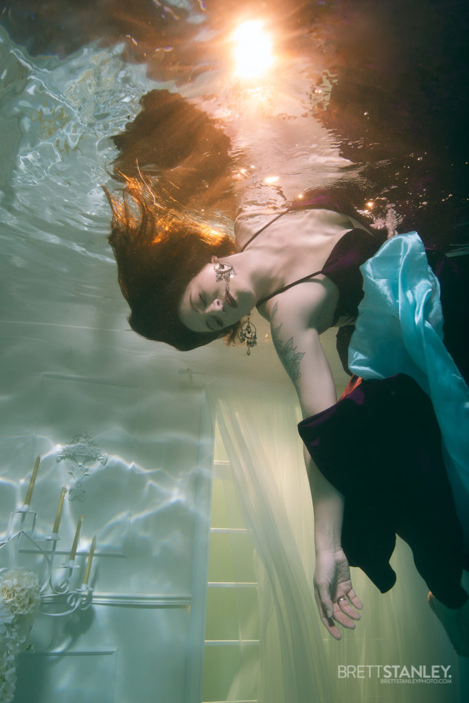 girl floating underwater for a photoshoot